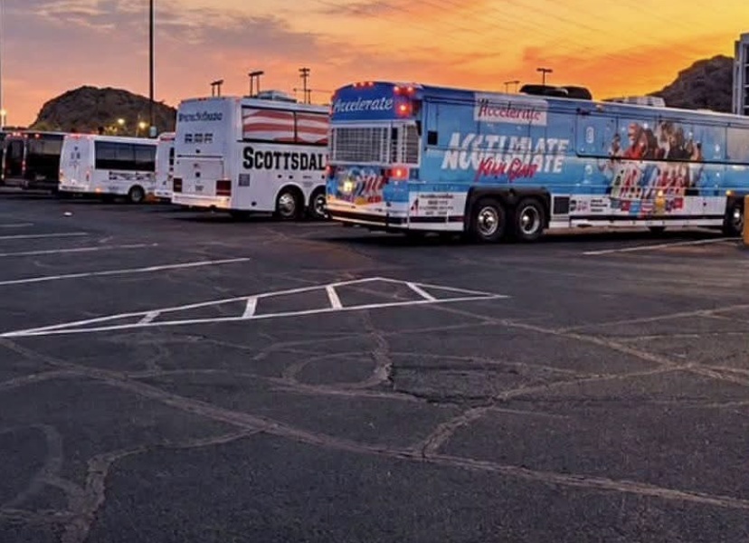 Buses lined up under an orange Arizona sunset